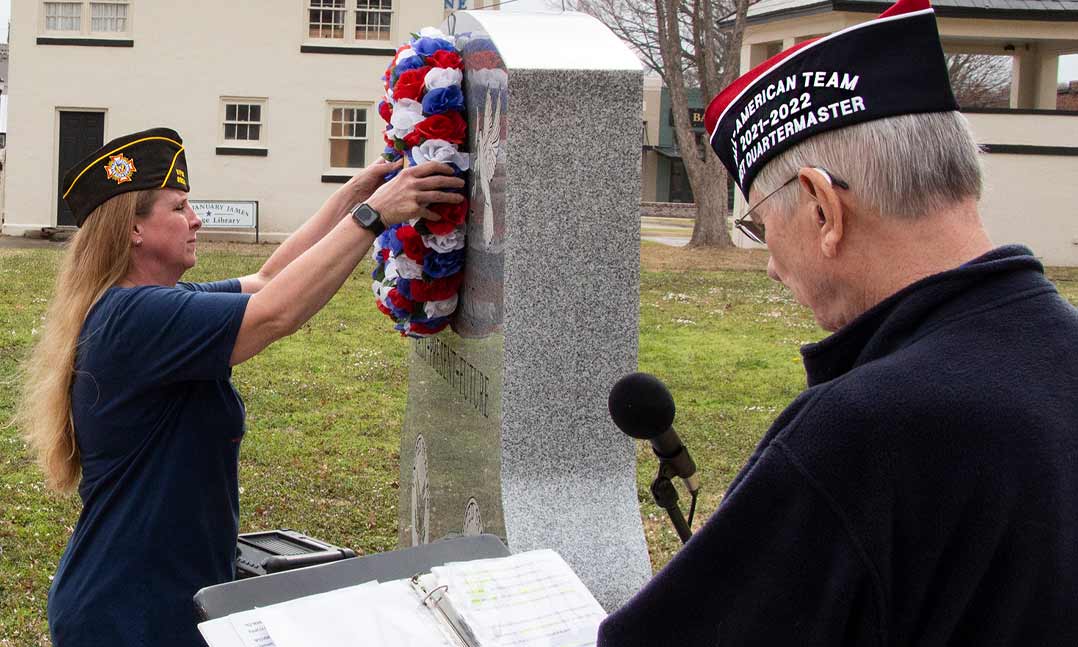Mary J. Roberts with VFW Post 8904 places a memorial wreath