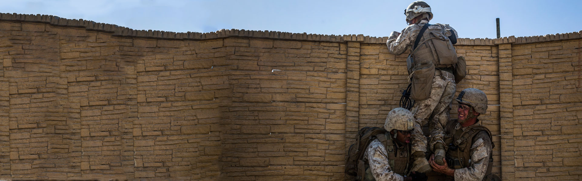 Soldiers climbing up a wall