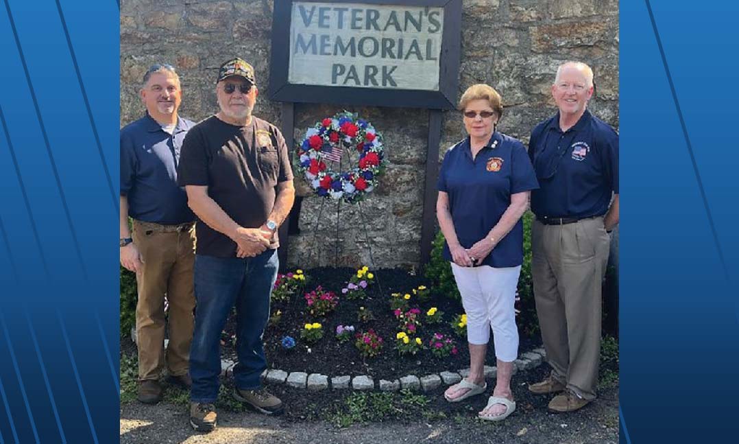 Russ Martin, center-left, and Audrey Martin, center-right, present a wreath Audrey made