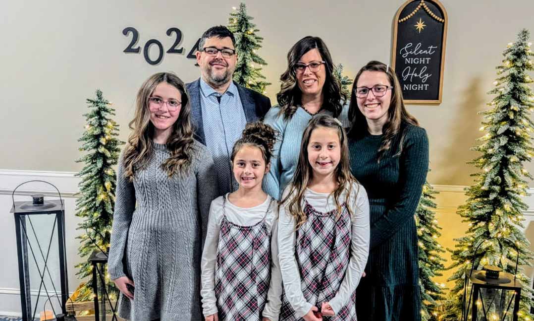 VFW’s “Sport Clips Help-A-Hero Scholarship” recipient Paul Phelps joins his wife Sarah and their four daughters in a Christmas photo