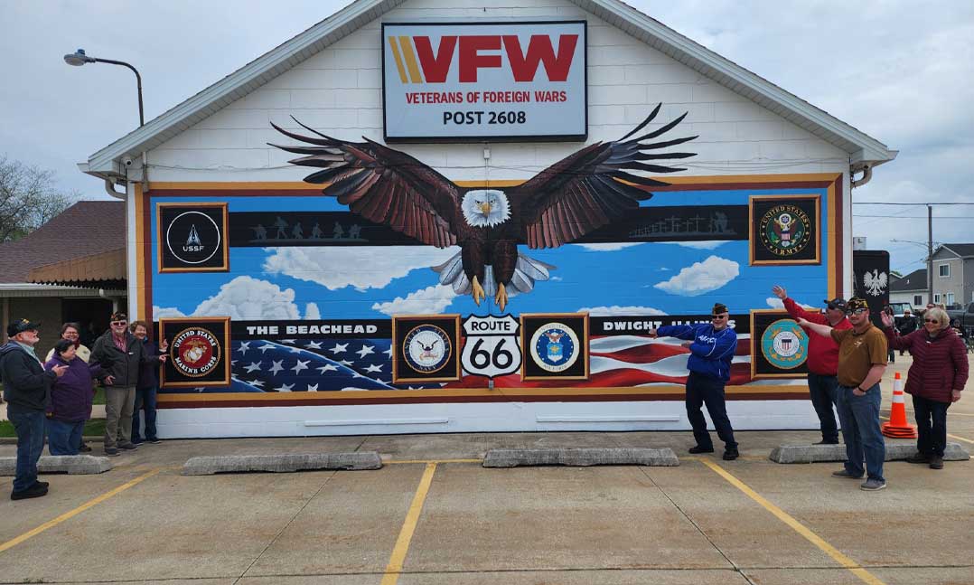 Members of VFW Post 2608 and its Auxiliary gather in May at the Dwight, Ill., Post in front of a new mural Stephan “Conman” Connors painted