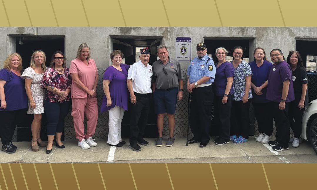 VFW Post 4442 Commander Gerald McMasters, center, donates a Purple Heart parking sign on Sept. 4, 2024