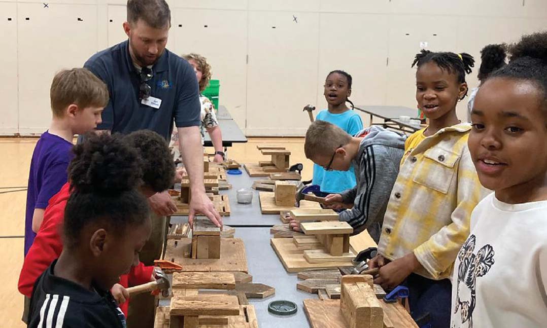 Karl Erickson, left, teaches a student how to build a birdfeeder