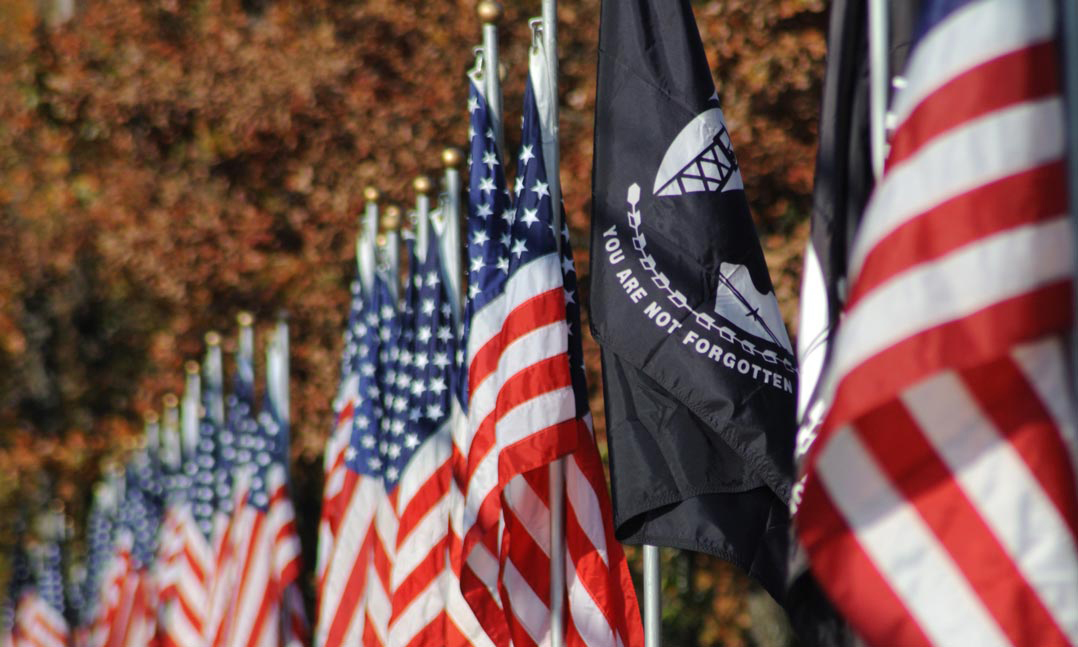 Row of US flags with a POW/MIA flag in the middle