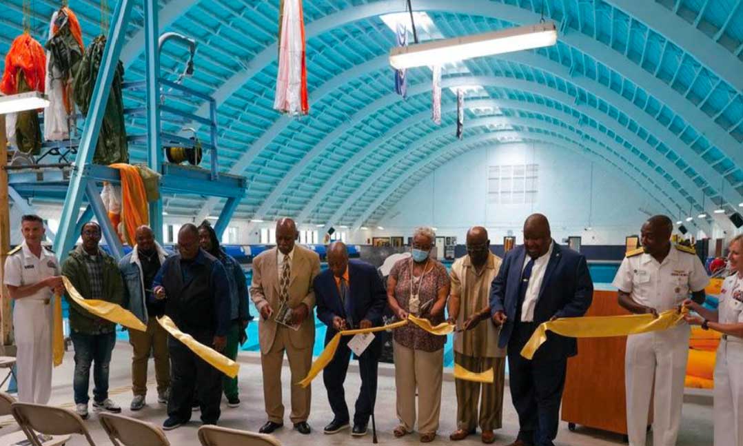 Navy leaders and family members of Charles French cut a ribbon at a pool dedication ceremony